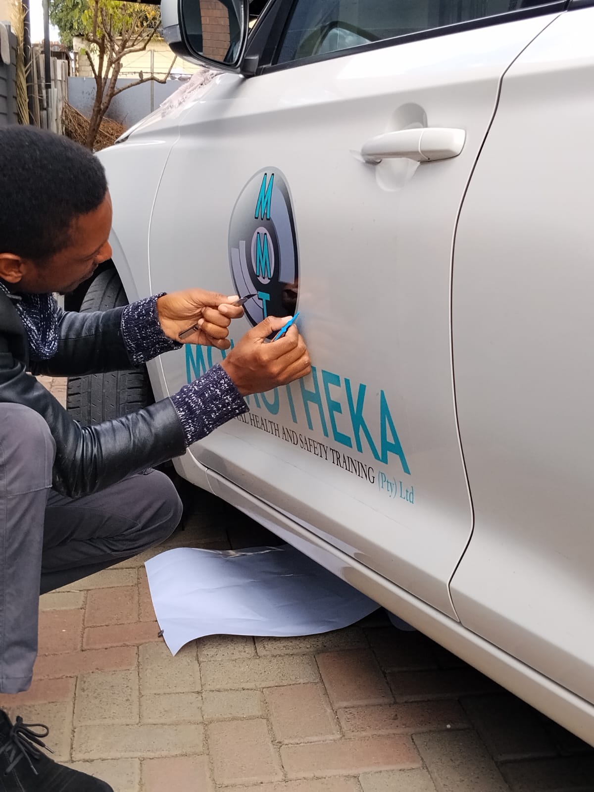 Definitive Brand Culture technician hand-applying vehicle branding decals
